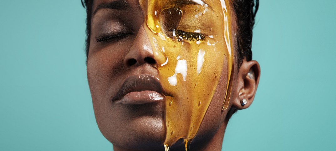 Closeup Portrait Of A Black Woman With A Honey On Her Face