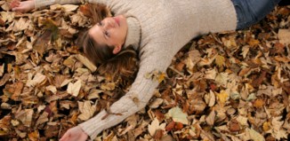 woman lying in fall leaves